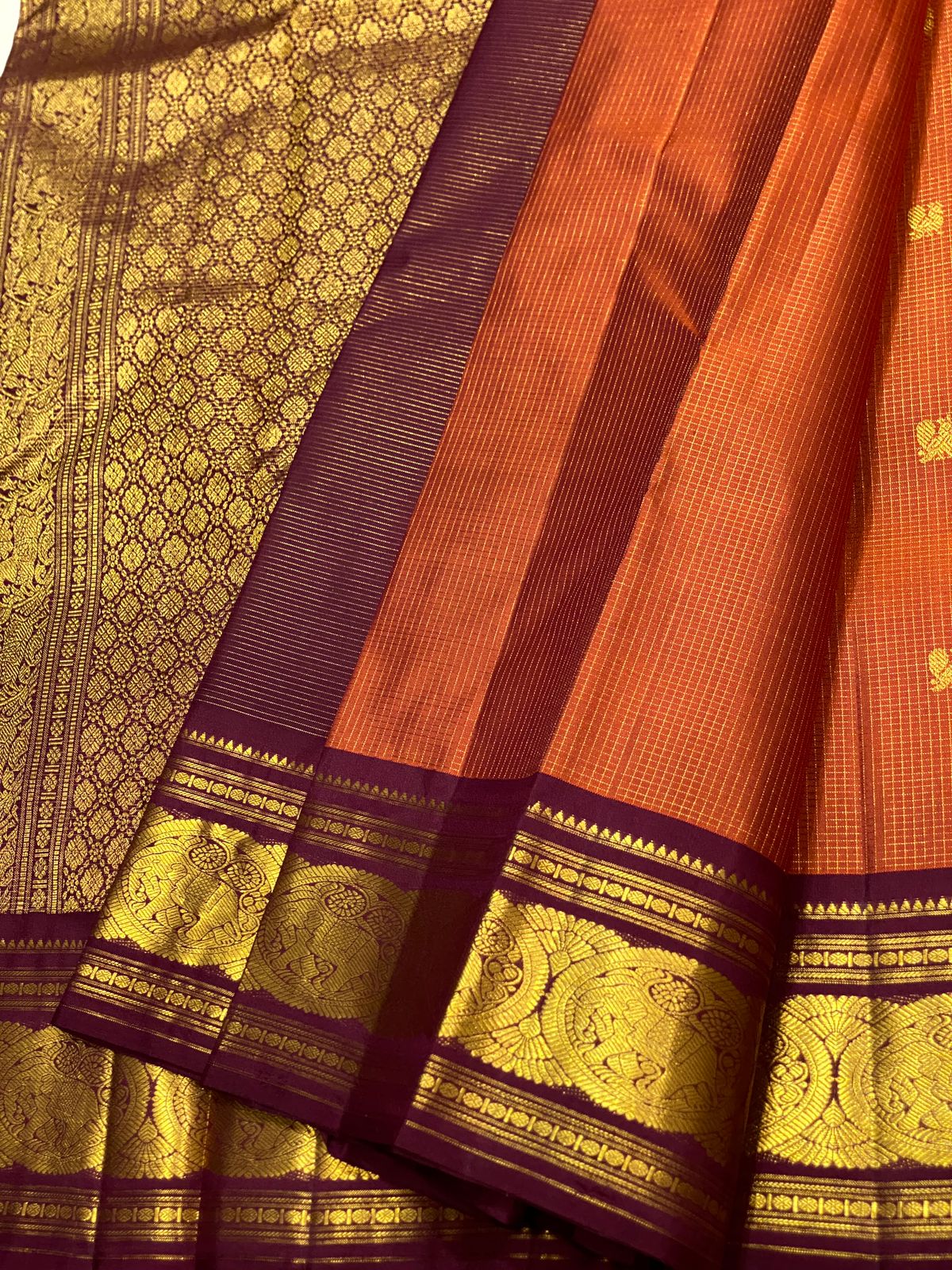 Uma 🌺 – Rust-Orange Kanchipuram Pure Silk Saree
Wide Deep Aubergine-Brown Borders with Sorgavasal Yaanai (Temple Elephant) Motifs
Rich Gold Brocade Pallu with Diamond pettu& Floral Vines