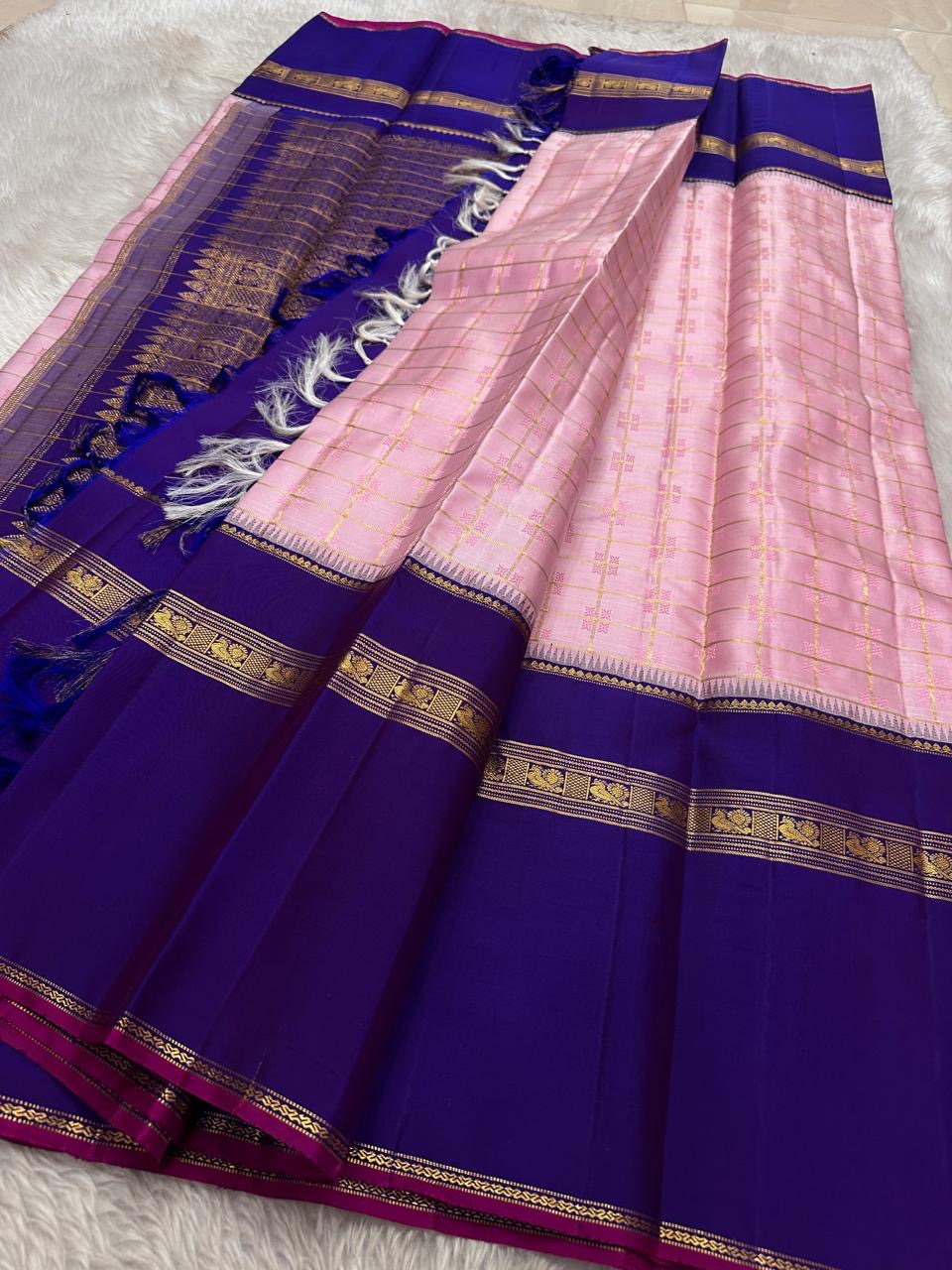 Anaar ✨ – Royal Purple & Lotus Pink Kanchipuram Pure Silk Saree
With Zari Kattam Checks, Mayil Motif Border & Grand Pallu
Korvai Contrast Weave in Regal Purple , 
Peacock & Floral Zari Panels, Raspberry Selvedge Finish
Silk Mark Certified