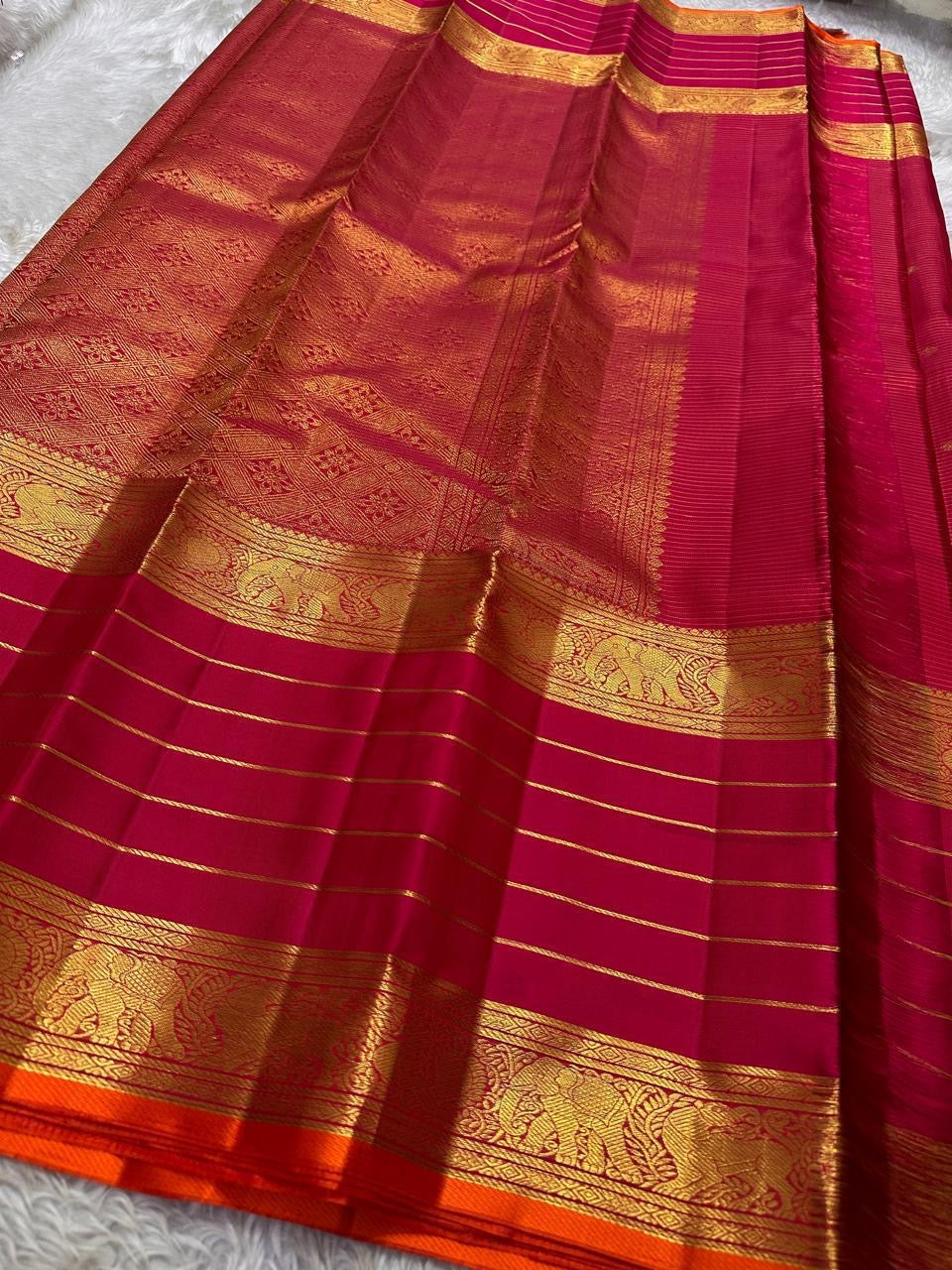 Full layout of pink-red Kanchipuram silk saree with horizontal zari stripes, elephant border and grand woven pallu.