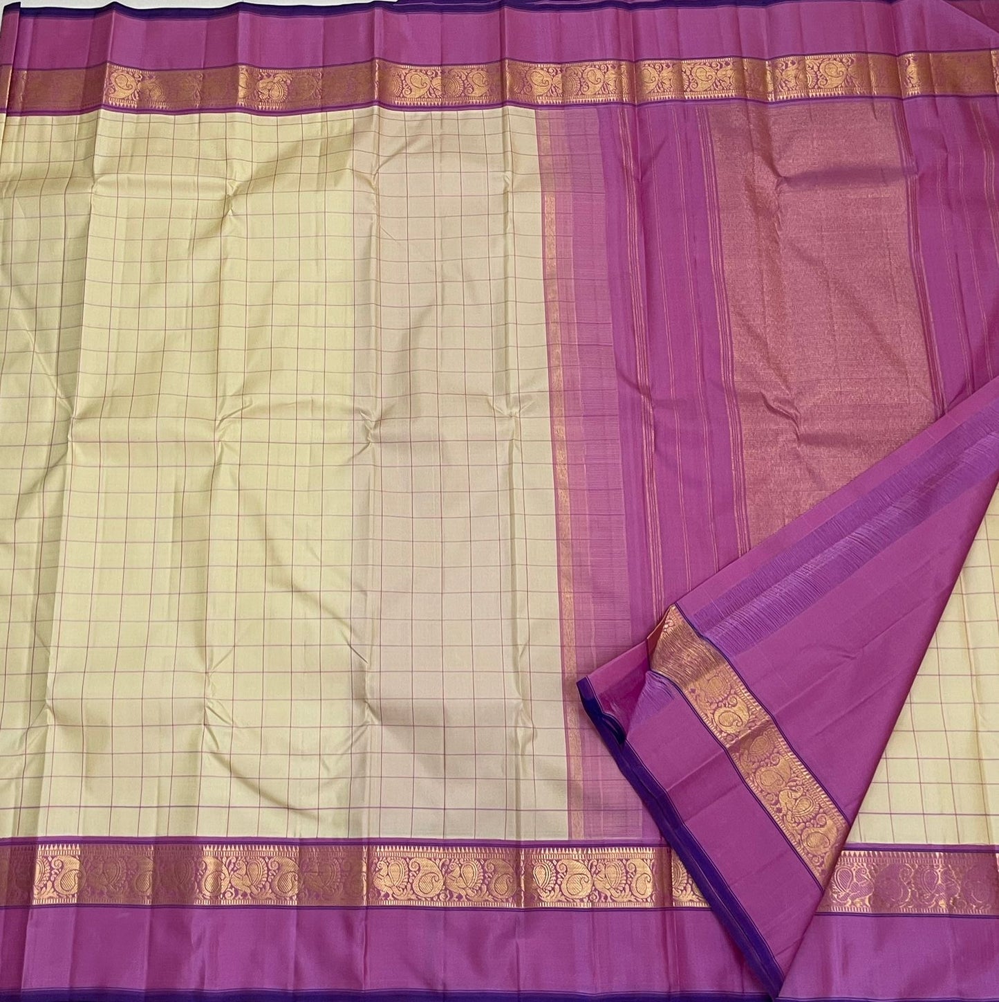 Lotus Kattam — Pure Kanchipuram Silk Saree
Butter-cream body with fine rose-pink kattam checks ✨
Rani-magenta zari border with lotus vines & paisley motifs 💖
Silk Mark Certified ✅ Free USA Shipping ✅ Ships in Two Weeks ✅