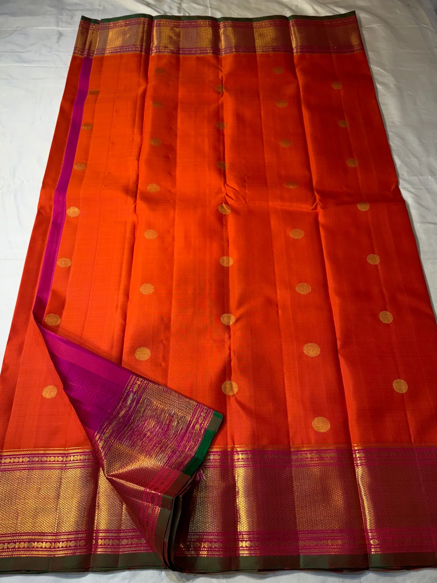 Kalpana  
Pure Silk Kanchipuram Saree  
Burnt Orange with Golden Buttas  
Intricate Magenta & Gold Zari Border