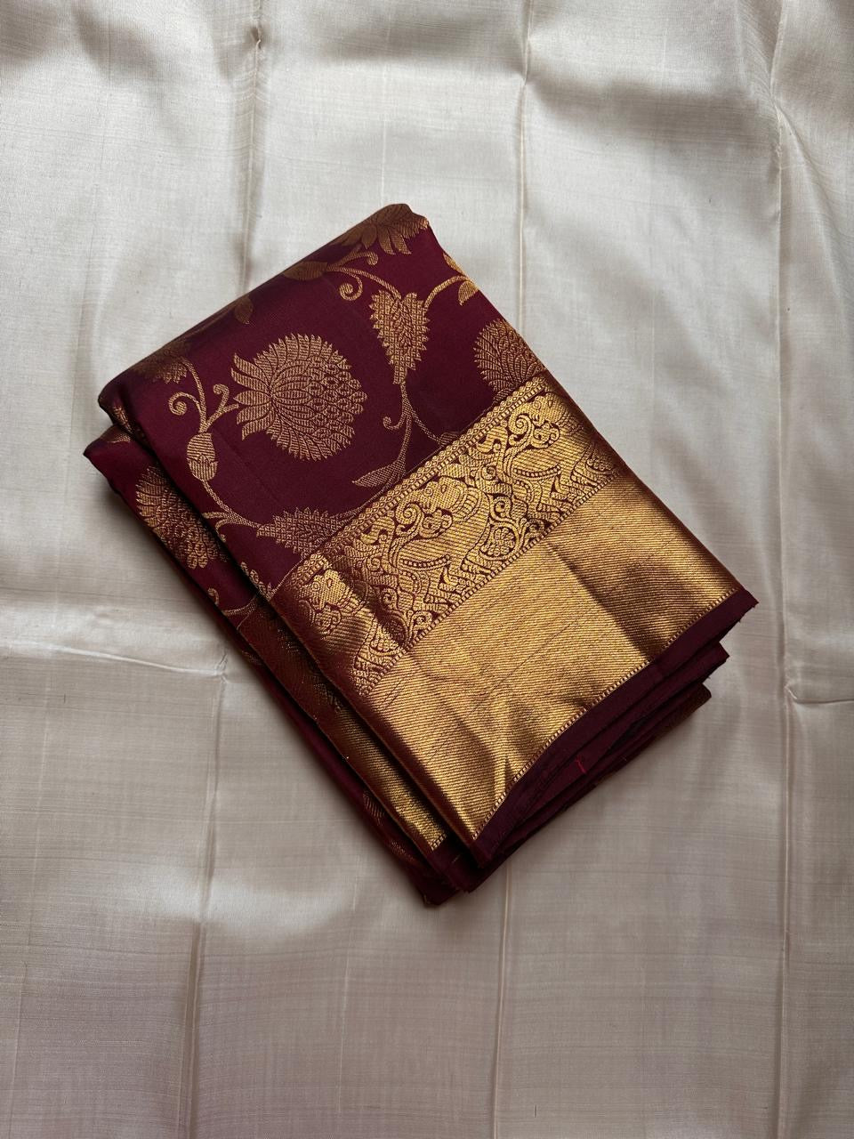 Tanvi – Coffee Brown Kanchipuram Pure Silk Saree with Floral Zari Jaal & Baavanji Border

Rich coffee brown silk adorned with delicate floral zari jaal creates a timeless elegance.
The bold Baavanji border and grand Varisaipettu pallu