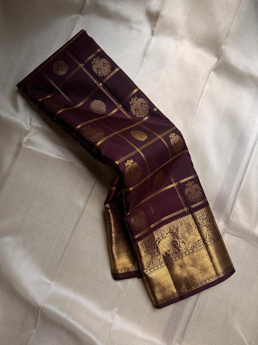 Ambaram – Coffee Brown

 — Pure Kanchipuram Silk

Elephant & Peacock Procession Zari Border • Coin & Gandaberunda Buttas

Geometric Diamond Brocade Pallu in Antique Gold

Handloom •

Silk Mark Certified • Ships in Two Weeks
