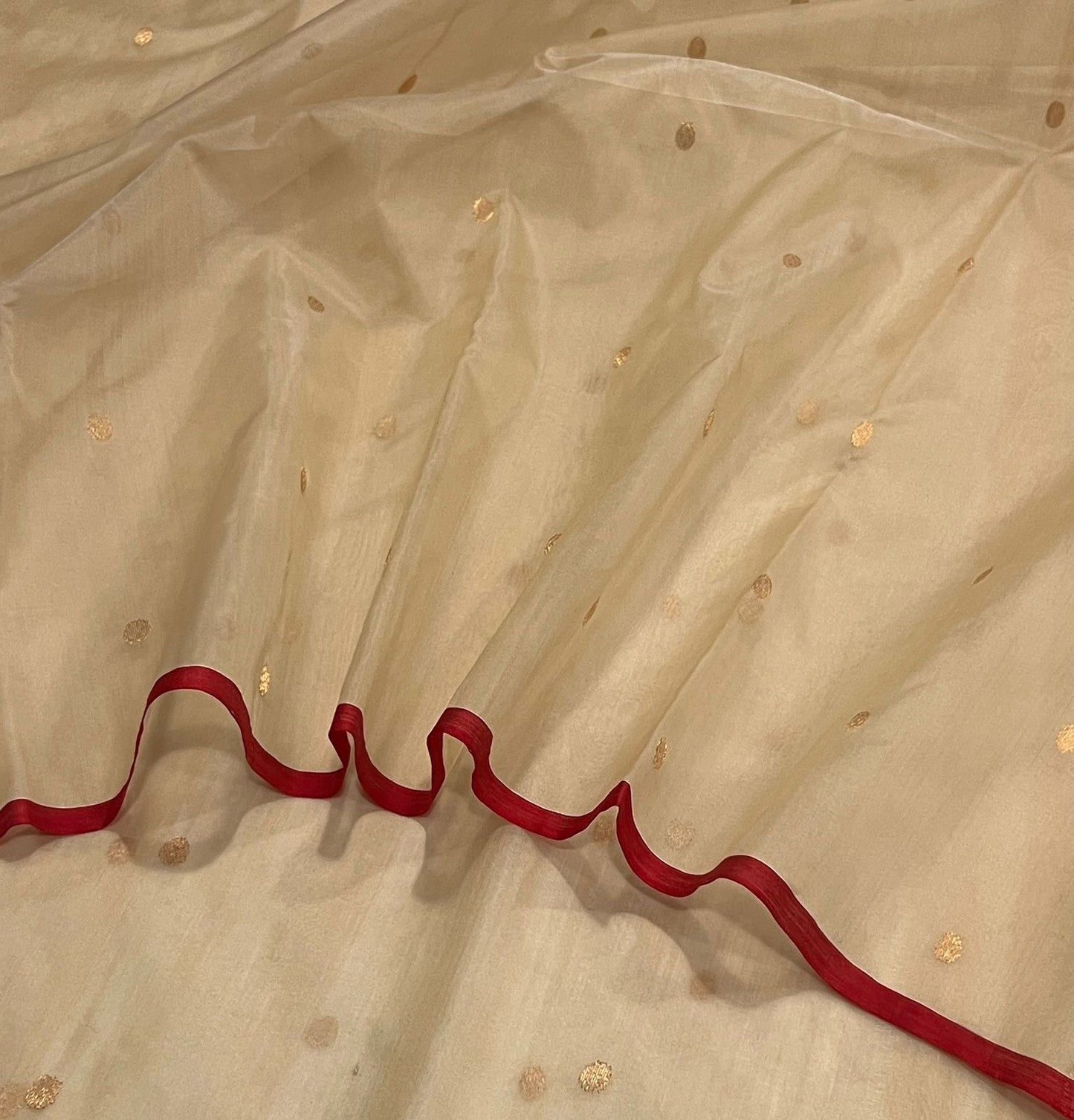 Sandalwood beige Chanderi silk saree showing softly luminous gold-toned zari pallu and deep red border