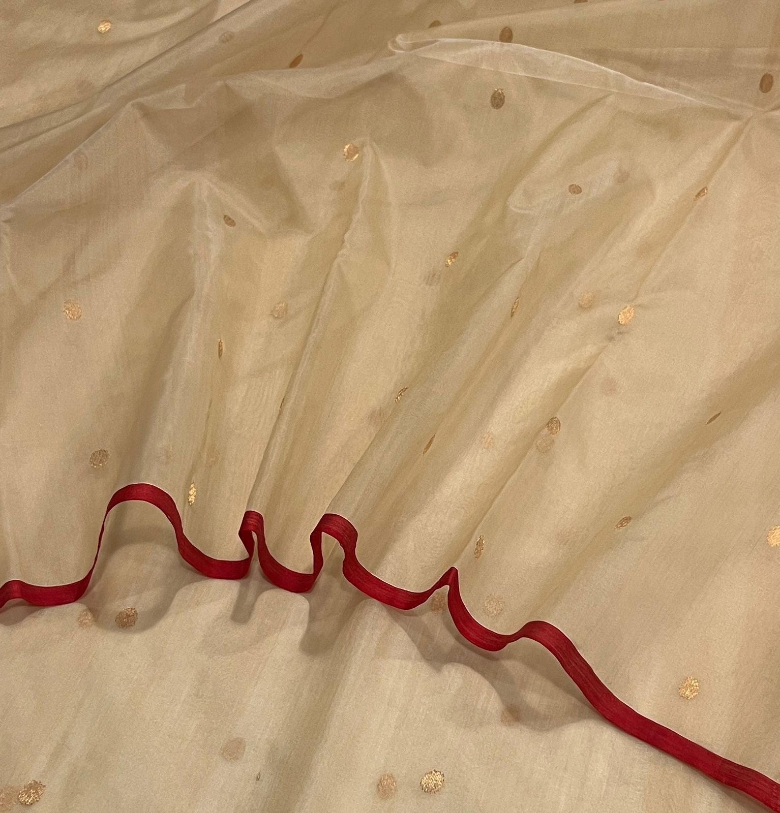 Sandalwood beige Chanderi silk saree showing softly luminous gold-toned zari pallu and deep red border