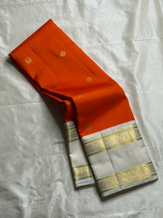 Kesar Chakram – Pure Kanchipuram Silk Saree
Rich Kesar Orange Body with Golden Chakram Buttas
Ivory Korvai Borders with Zari Rosette Motifs & Green Selvedge
Grand Ivory-Gold Brocade Pallu with Orange Tassels
Silk Mark Certified | ships in 2 weeks