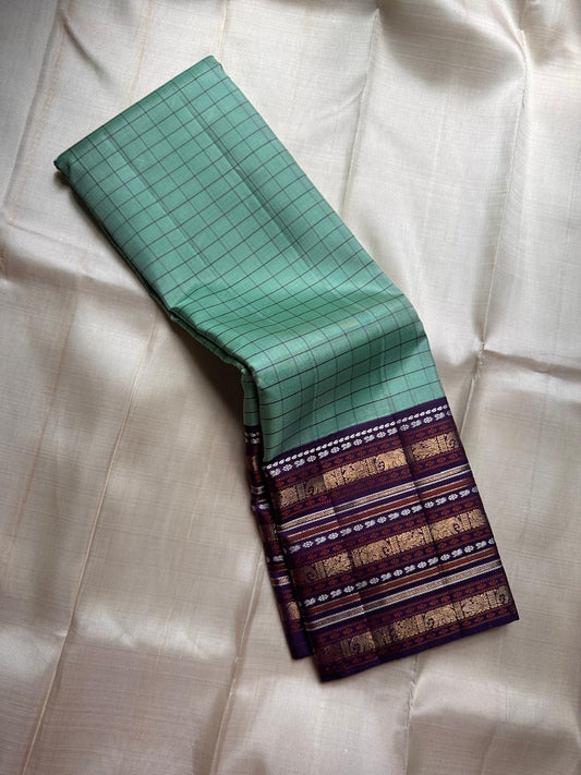 Sage Glory – Mint Green & Purple Kanchipuram Silk Saree ✨
Elegant Kattam Checks with Grand 3g zari Korvai Border
Rich Purple Pallu Woven with Traditional Motifs
Coordinated Blouse Piece with Matching Zari Finish

Silk Mark Certified, delivery in 2 weeks