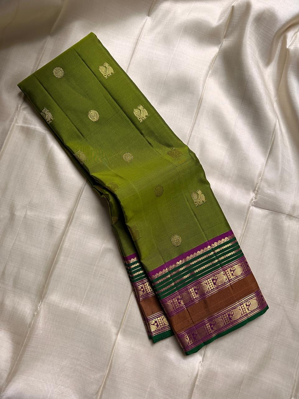 Meadow Bloom ✨ – Pure Kanchipuram Silk Saree
Meadow Green Body with Gold Zari Buttas
Contrast Brown–Green Border with Peacock Motifs
Majestic Magenta-Pink Zari Brocade Pallu
Handwoven Elegance – Perfect for Weddings & Festive Wear