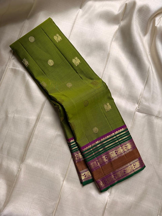 Meadow Bloom ✨ – Pure Kanchipuram Silk Saree
Meadow Green Body with Gold Zari Buttas
Contrast Brown–Green Border with Peacock Motifs
Majestic Magenta-Pink Zari Brocade Pallu
Handwoven Elegance – Perfect for Weddings & Festive Wear
