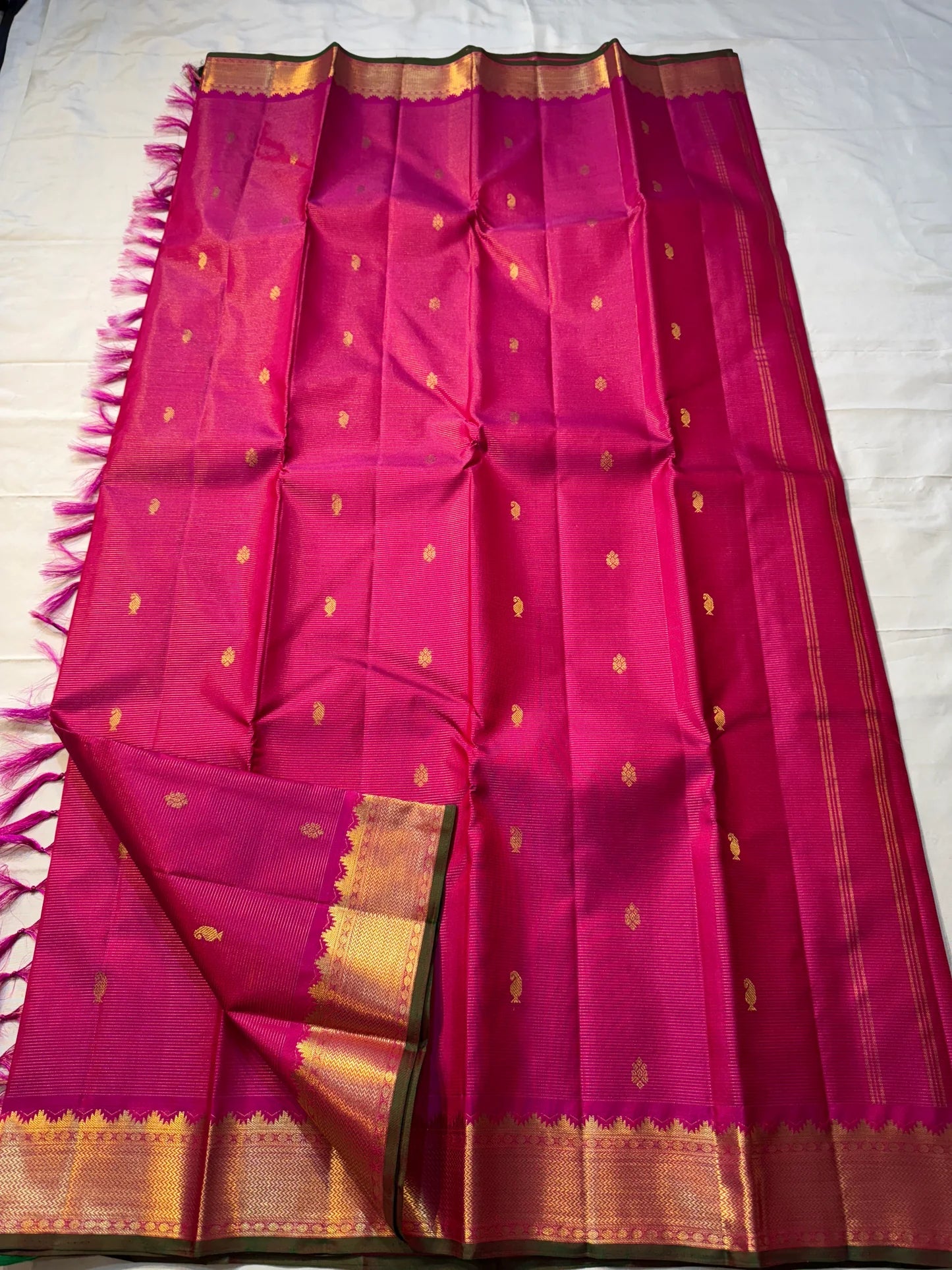 Rani Vairaoosi – Pure Kanchipuram Silk 💗

Fine Pinstriped Weave with Gold Buttas ✨

Antique-Gold Zari Border & Green Selvedge 🌿

Grand Zari Brocade Pallu with Medallion Checks 🪔

Silk Mark Certified • Ships in Two Weeks • Free USA Shipping