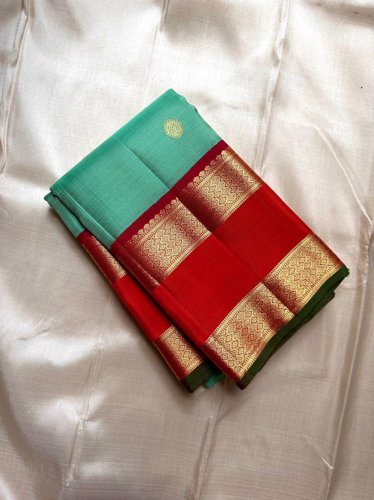 Poomugam Pachai
Pure Silk in Tender Mint & Kumkum Red
Zari-Woven Grandeur in korvai  Contrast