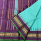 Gopura Neelam — Kanchipuram Pure Silk Saree

 

 

Teal-green body with micro kattam checks for a sleek drape

Regal aubergine korvai border with gopuram/temple motifs & gold zari

Parrot-green selvedge for a fresh, festive pop of contrast

Aubergine pall