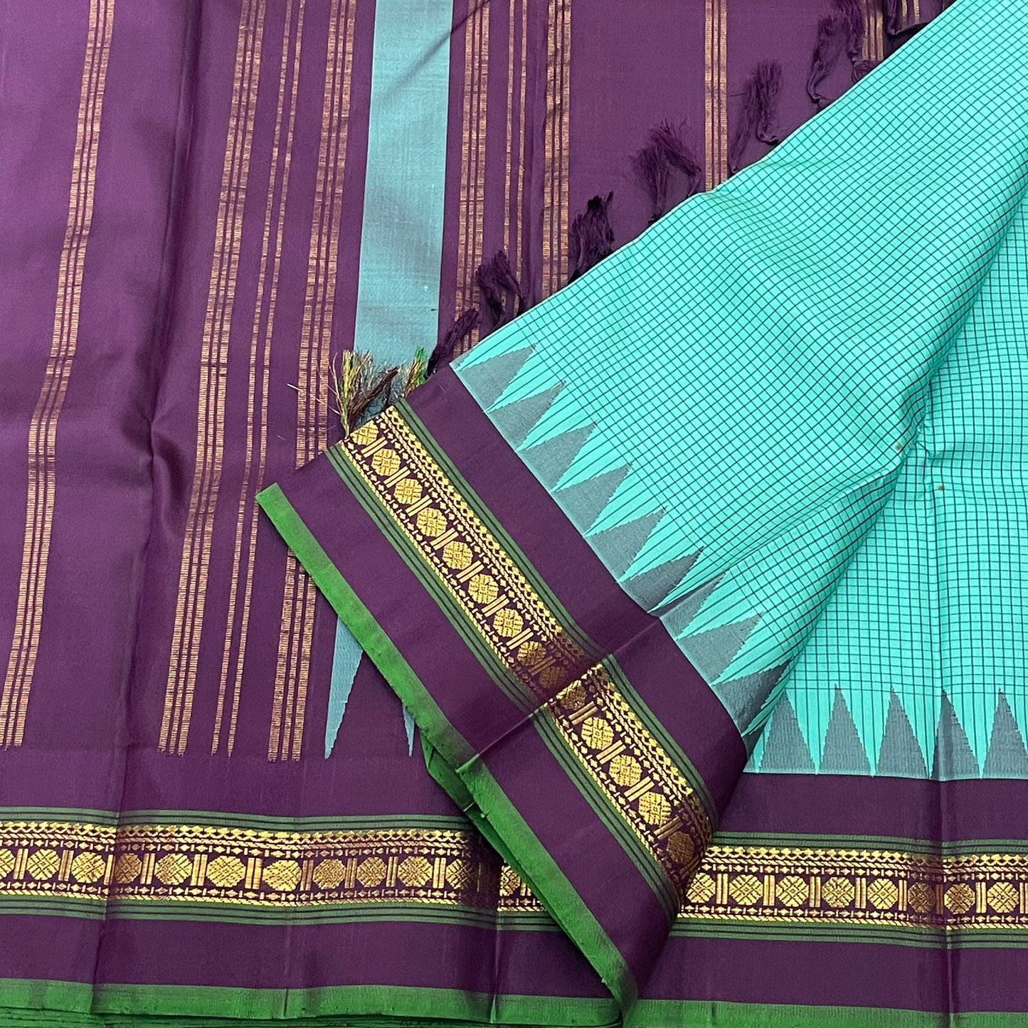Gopura Neelam — Kanchipuram Pure Silk Saree

 

 

Teal-green body with micro kattam checks for a sleek drape

Regal aubergine korvai border with gopuram/temple motifs & gold zari

Parrot-green selvedge for a fresh, festive pop of contrast

Aubergine pall