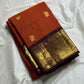 Rust Orange & Wine Korvai – Pure Kanchipuram Silk Saree
Burnt rust-orange shot body with dainty gold paisley buttas
Deep wine korvai borders in antique gold—Annapakshi & Yaali medallions
Grand wine pallu with full-zari jaal & temple panels
Silk Mark