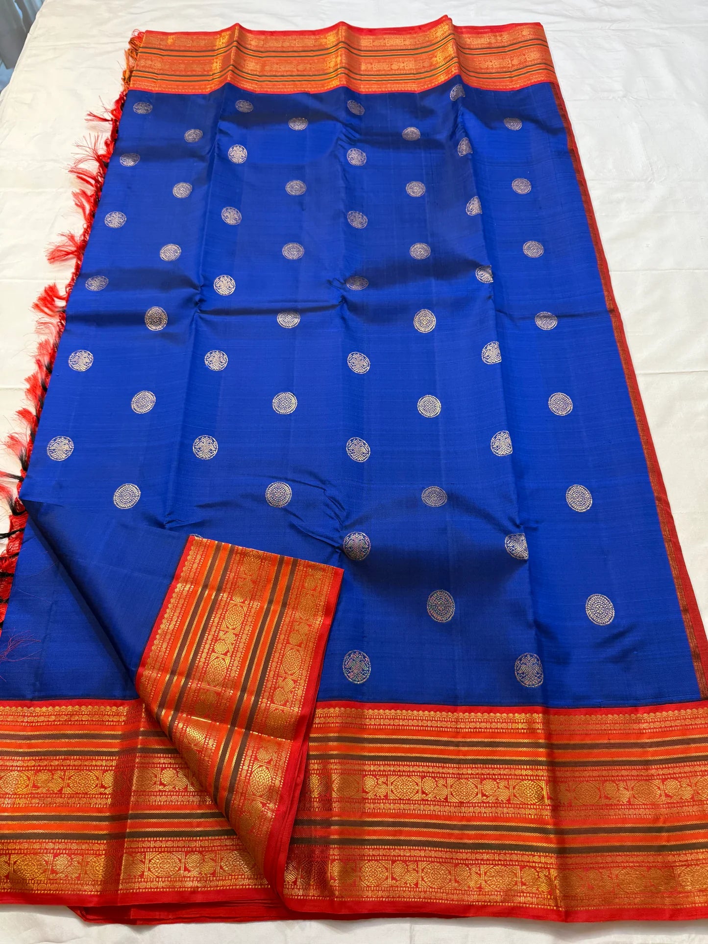 Royal blue Kanchipuram silk saree full view with coin buttas and contrast red zari border