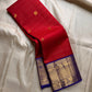 Raaga – Red and Blue Pure Kanchipuram Silk Saree with Gold Zari Border
Features a striped red body with small gold buttas and a royal blue pallu.
Finished with intricately woven peacock motifs in pure zari across the border.