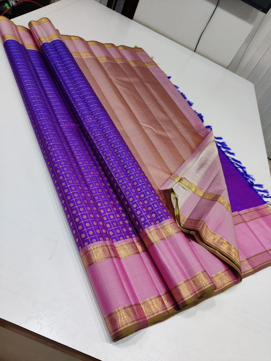 Violet Bloom – Pure Kanchipuram Silk Saree
Royal purple body in fine kattam checks with oval buttas ✨
Rose-pink korvai borders in ornate 2g zari

Silk Mark Certified, delivery in 2 weeks