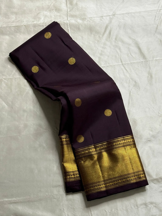 Nagavalli – A Midnight Jamun Dream in Kanchipuram Silk, Woven with Gold Coin Buttas, Temple-Inspired Arai Maadam Border, and Rudhraksham Seer in Lustrous Zari