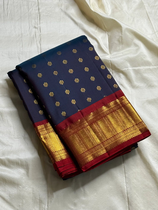 Midnight Neelam Flower Butta — Kanchipuram Pure Silk


Deep midnight neelam (navy) body with scattered gold flower buttas

Korvai contrast maroon borders with grand + geometric zAri motifs 

Rich zari pallū with ornamental motifs; hand-twisted tassels