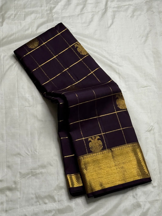 Plum Zari Kattam — Pure Kanchipuram Silk Saree
Rich plum body with gold kattam grid & Gandaberunda buttas ✨
Antique-gold brocade border & grand zari pallu • Silk Mark Certified • Free Shipping within USA • Ships in Two Weeks