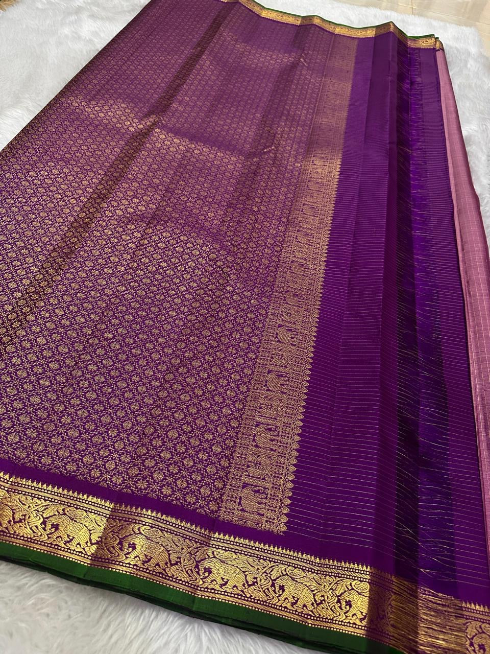 Petal Oosikattam ✨ – Pure Kanchipuram Silk Saree
Radiant Petal Pink Body in Oosi Zari Kattam Weave with Buttas
Deep Purple Korvai Border with Green Selvedge & Elephant Motifs
Majestic Purple Pallu with Intricate Gold Zari Brocade
Silk Mark Certified |
