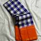 Indigo–Tangerine Checkmate — Pure Silk Kanchipuram
Bold indigo–lilac–white buffalo checks with ash accents ✨
Vibrant tangerine korvai border with temple (reku) teeth 🌸
Solid tangerine pallu with fine thread stripes & tassels 🪔
Silk Mark Certified •