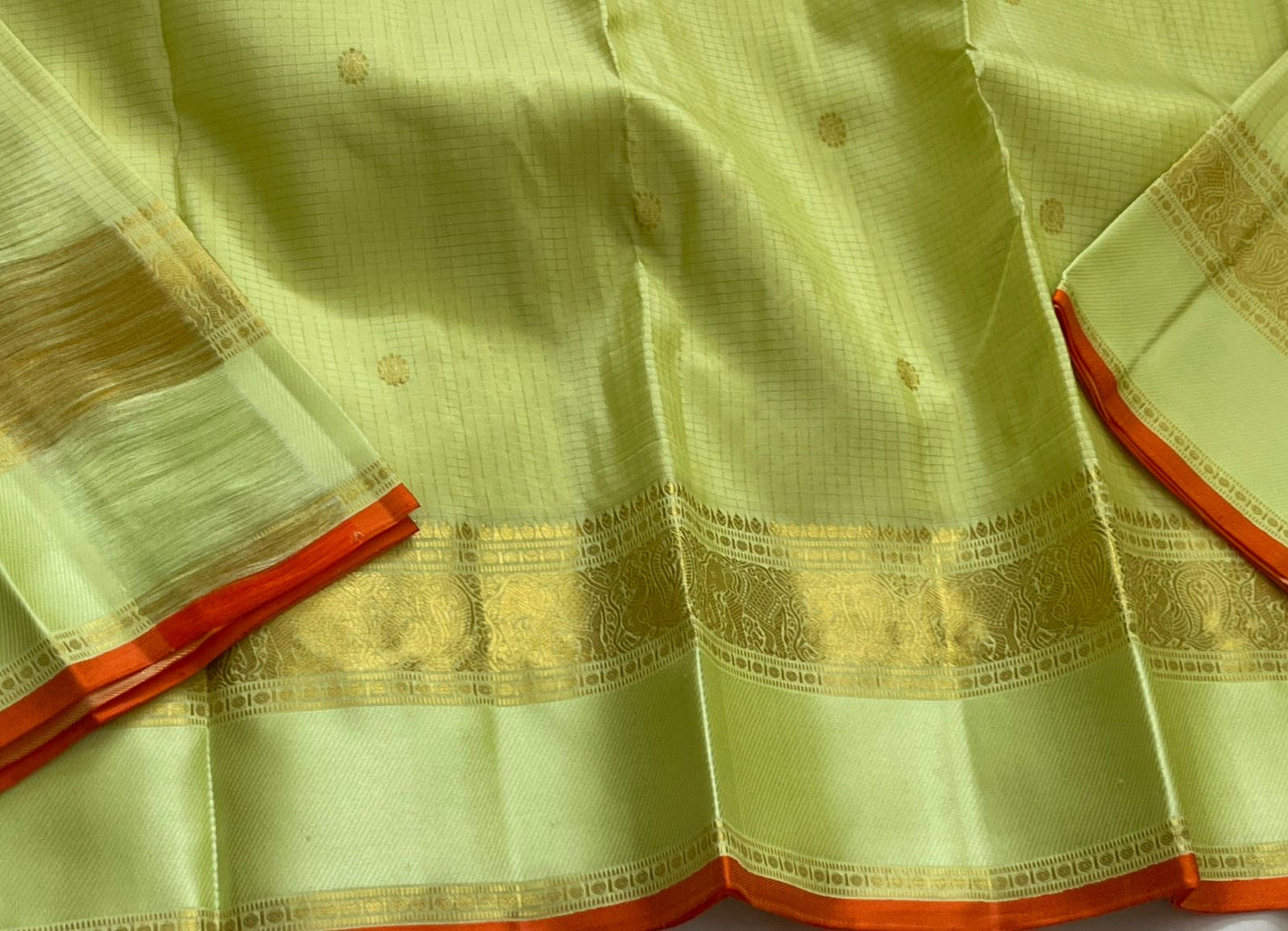 Meadow Shine — Kanchipuram Pure Silk Saree

Pastel meadow-green body with micro kattam checks & zari buttas

Antique zari borders woven with vine & elephant motifs

Warm kesari-orange selvedge a radiant edge . Silk mark cert￼. Free shipping within USA