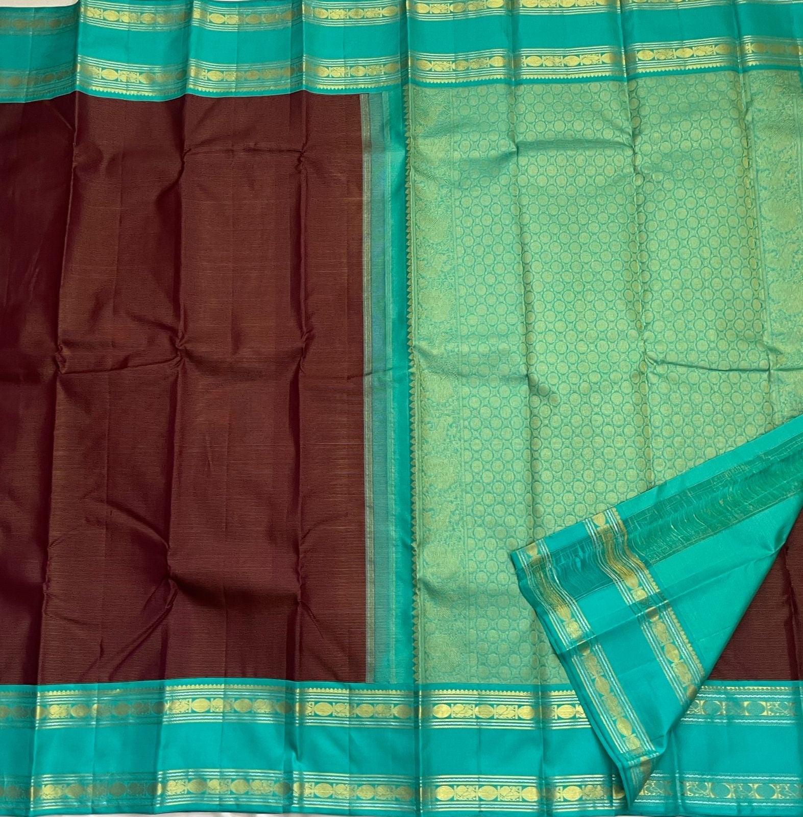 Rich teal pallu detail on deep brown Kanchipuram silk saree