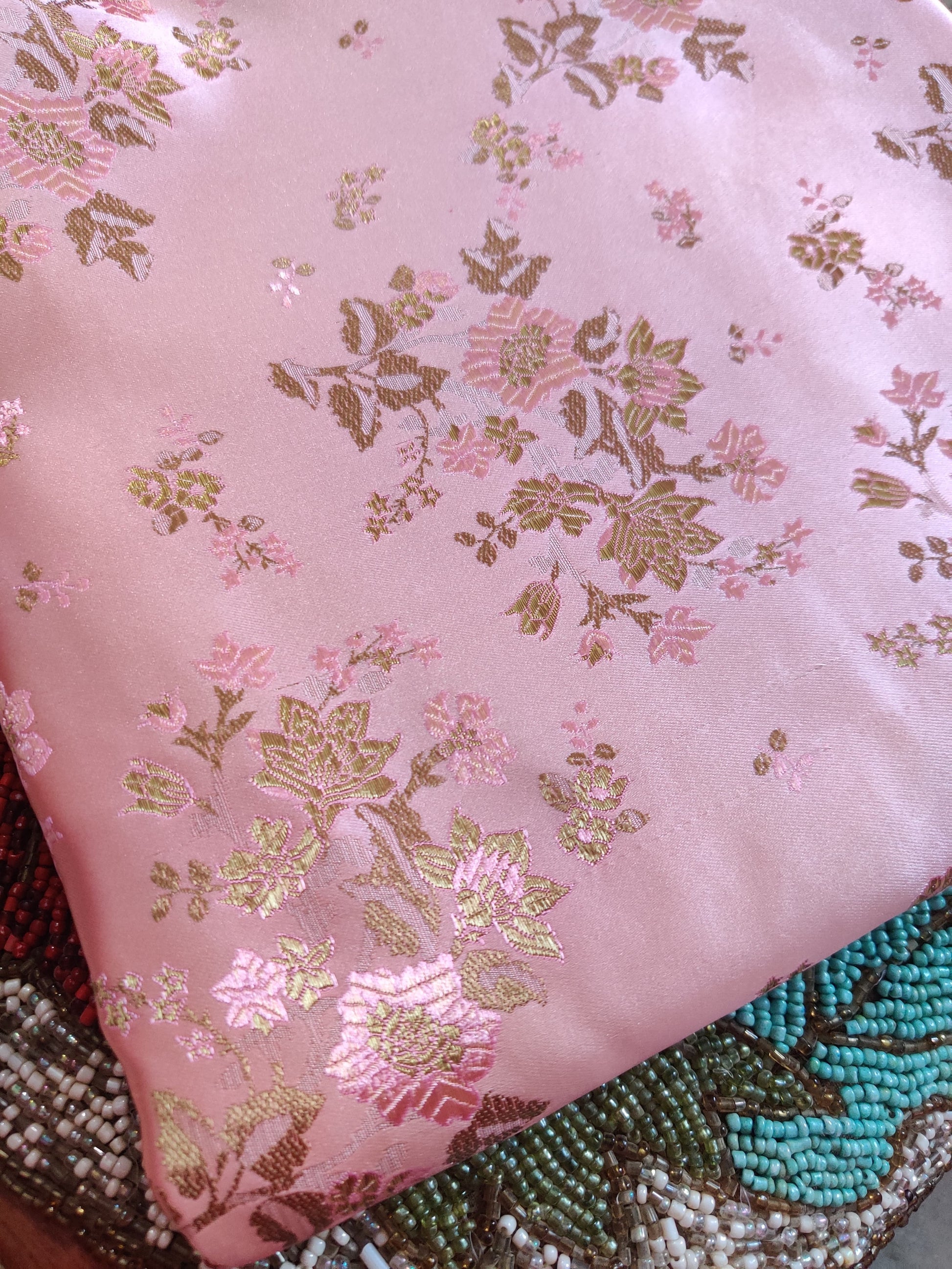 Close-up of structured Parcha silk fabric showing dense weave and refined zari woven work