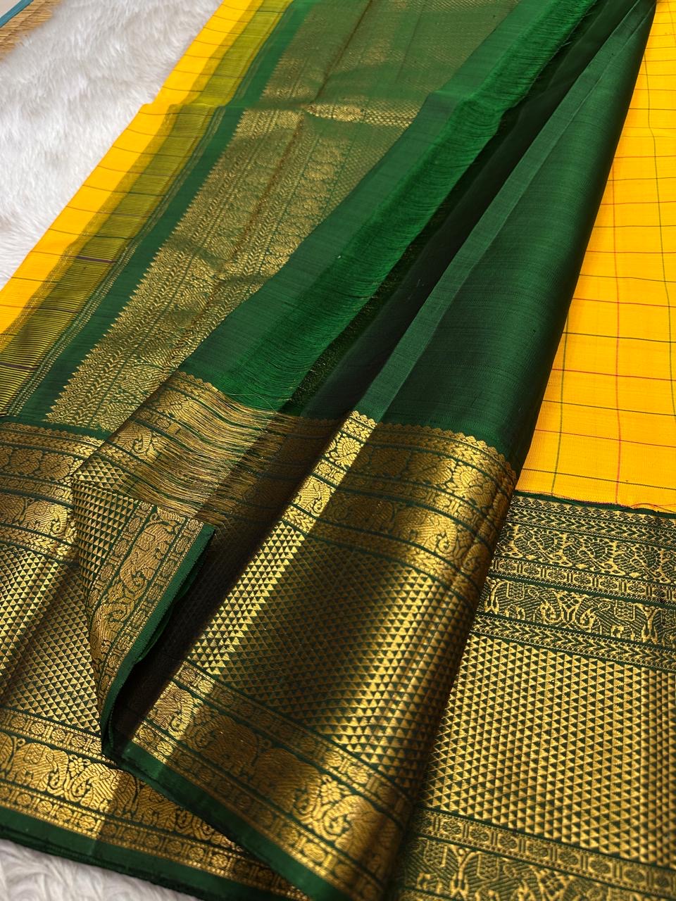 Manjal Pachai Kattam
Pure Kanchipuram Silk Saree – Marigold Yellow Body with Green Checks & Petite Zari Buttas
Deep Green Korvai Borders with Rich Gold Zari Weave & Traditional Elephant Motifs
Silk mark certified , ships in 2 weeks