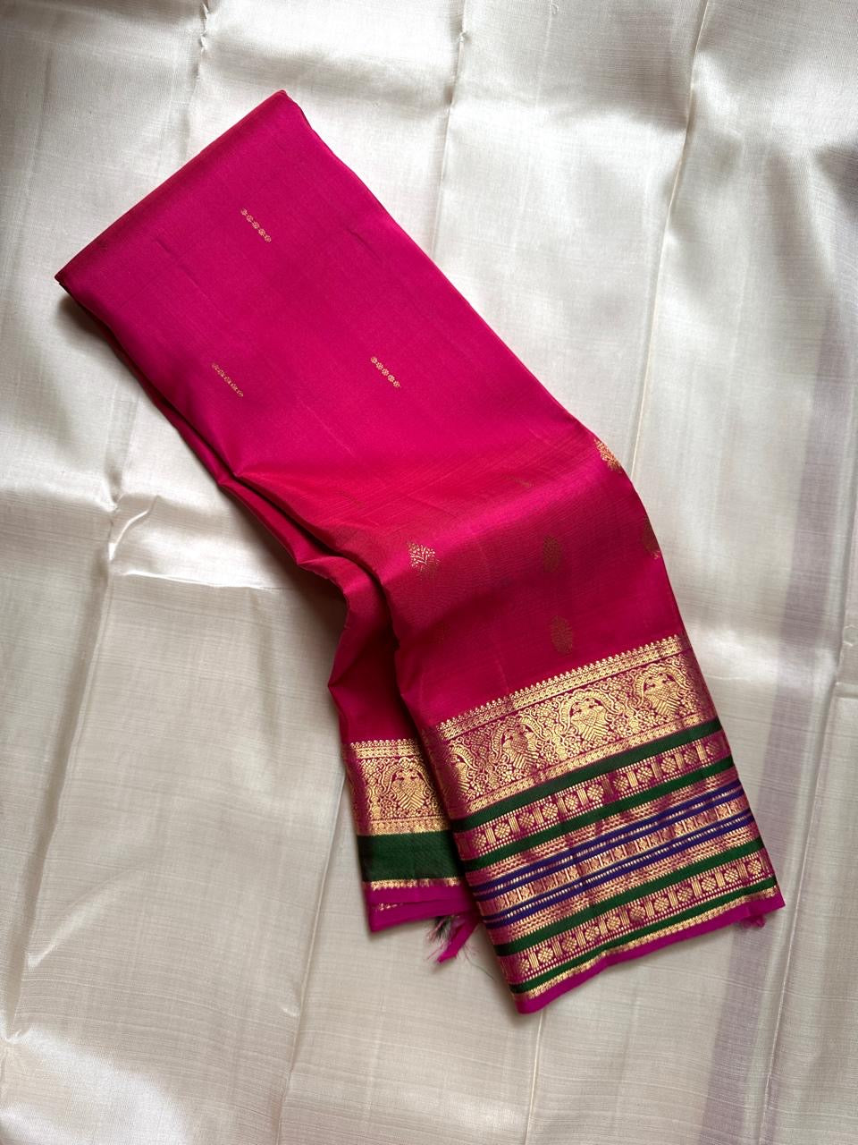 Kaamini ✨ — Fuschia Pure Kanchipuram Silk Saree
With Scattered Gold Zari Buttas on Lustrous Body
Bold Striped Korvai Border in Green & Blue Accents
Grand Fuschia Pallu Woven in Intricate Gold Zari
Contrast Blouse with Matching Zari Border Finish