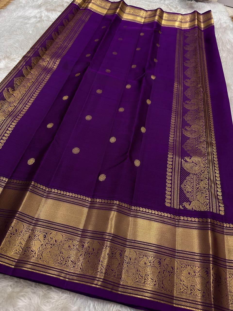 Ponvandu & Purple Butta — Pure Kanchipuram Silk Saree
Antique mustard body with gold zari buttas & rich purple borders
Peacock-woven zari motifs and temple serrations across the grand pallu
Silk Mark Certified • Free Shipping within USA • Ships in Two Wee