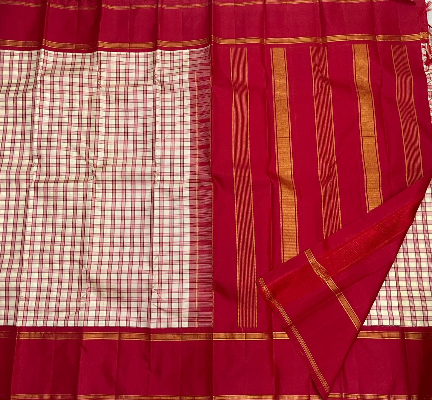 Full saree layout showing cream and red checks on one side and a deep red pallu with vertical gold zari woven stripes.