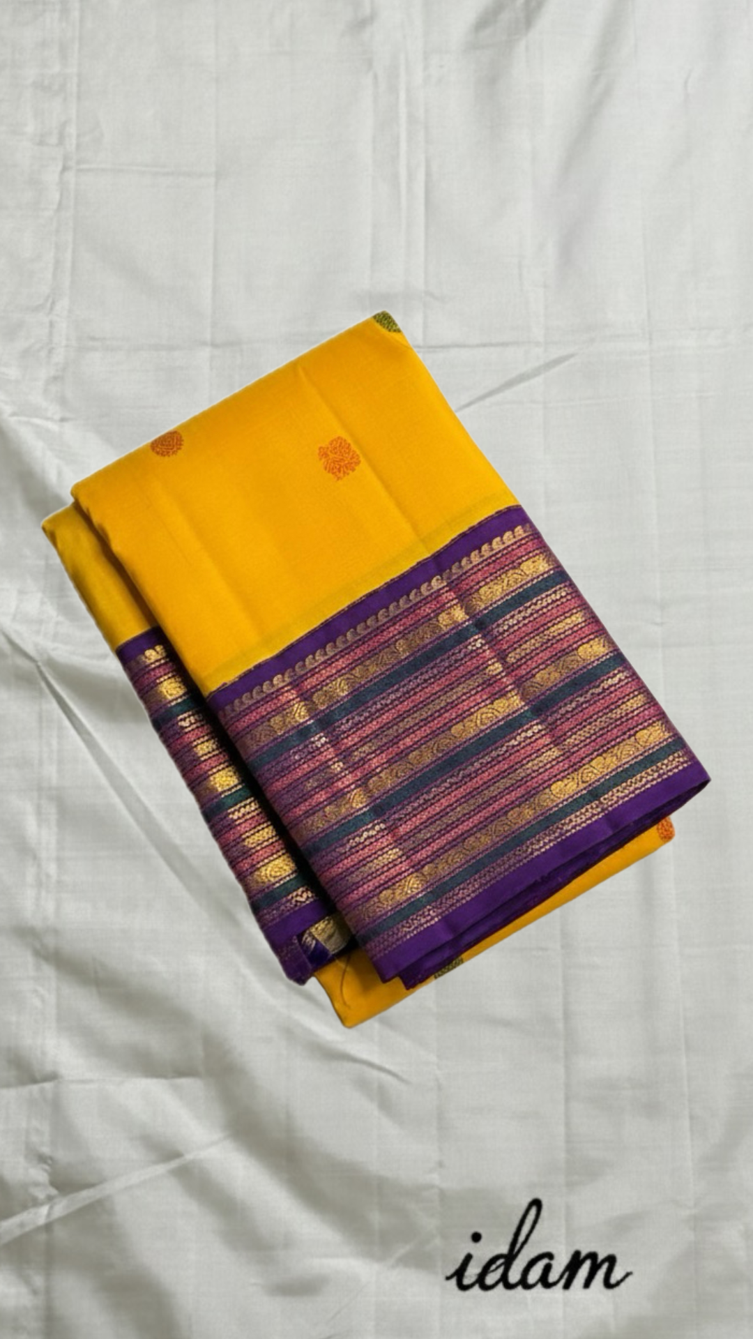 Swarna Kanakam Mayil Chakram — Pure Kanchipuram Silk Saree
Radiant turmeric-gold body adorned with silk-thread mayil and chakram buttas, framed by a regal vadamalli zari-woven korvai border and rich purple pallu.
Silk Mark Certified • Blouse Stitching Ava