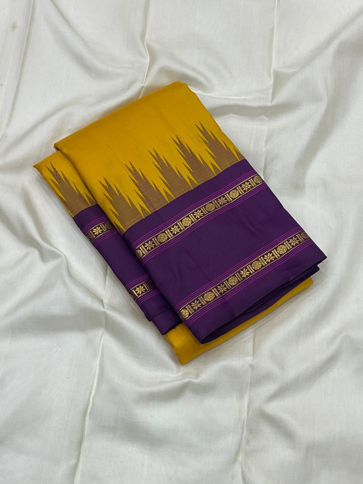 Suvarna Nitya
Mustard–Purple Kanchipuram Silk Saree
Heritage Temple Reku • Gold Zari Borders • Silk Mark Certified