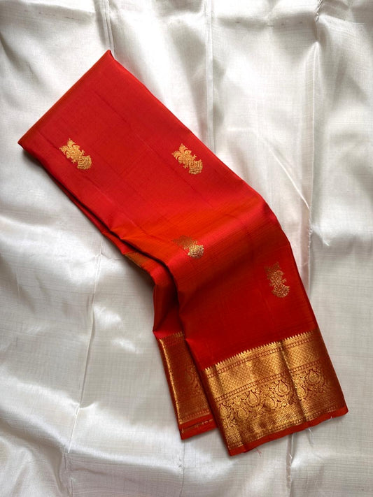Red pure Kanchipuram silk saree featuring scattered gold peacock motifs and intricate gold zari border.
