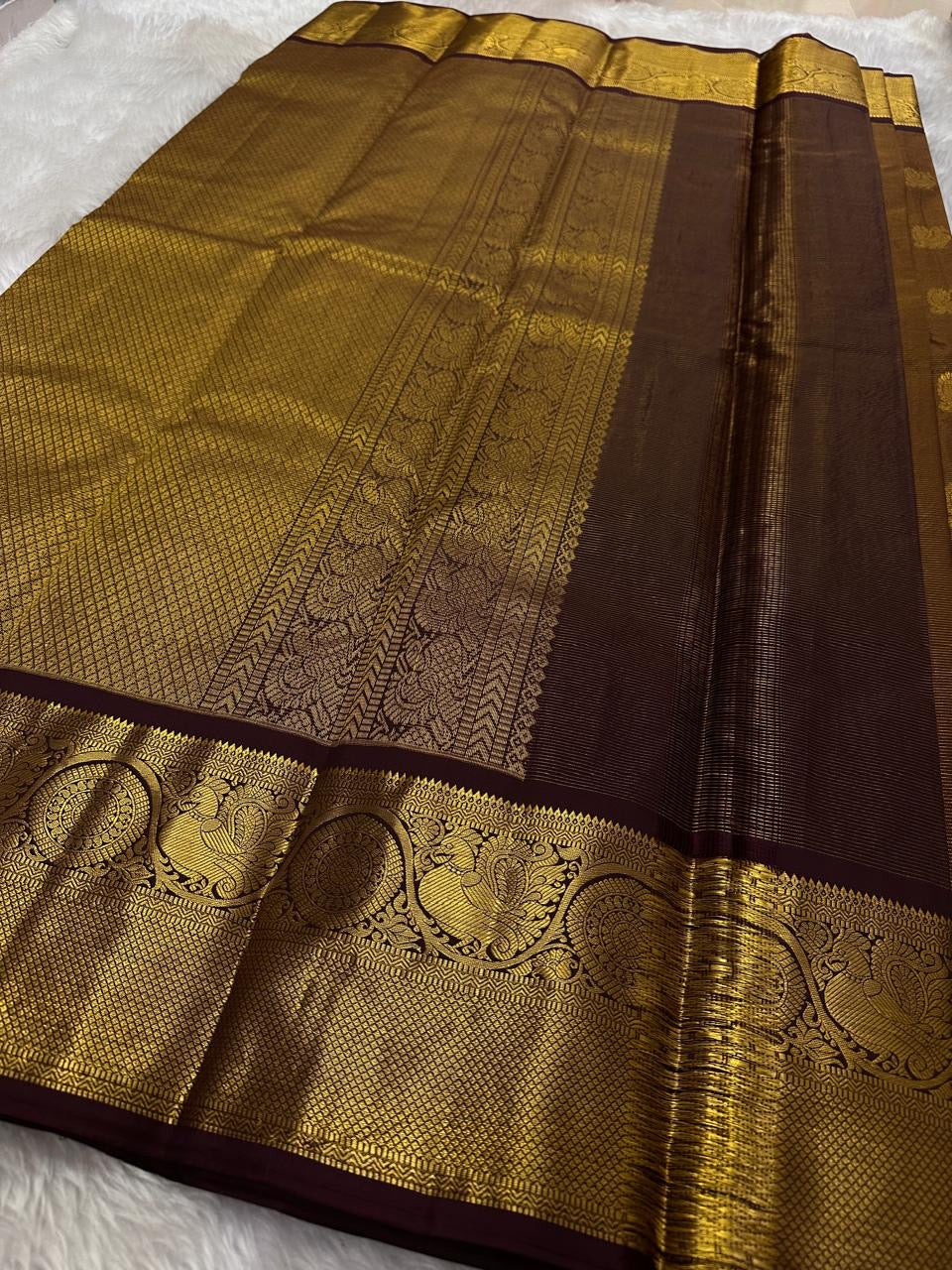Full view of deep rustic brown with a soft petal pink pallu Kanchipuram saree showing butta placement across the body.