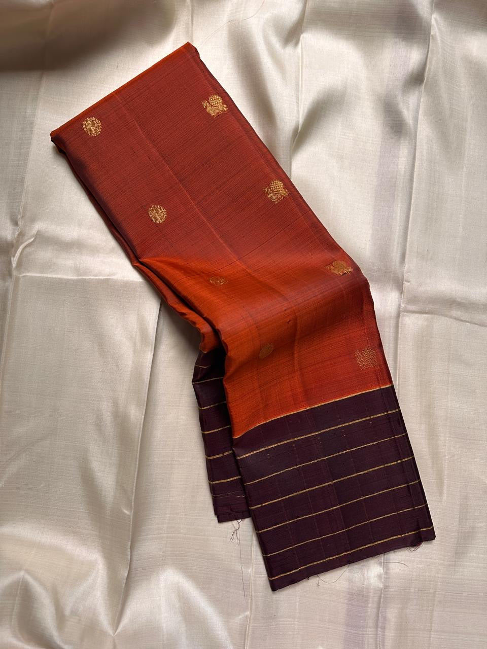 Poornima Kalyani
Burnt Orange & Cocoa Kanchipuram Silk Saree
Zari Buttas · Grid Borders · Silk Mark Certified
