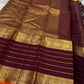 Full layout of maroon Kanchipuram silk saree with gold horizontal stripes, orange selvedge and grand zari pallu and borders.