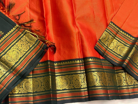 Aruna Mayil Chakram
Pure Kanchipuram Silk Saree – Reddish-Orange Body with Gold Zari Chakram Buttas
Contrast Bottle Green Korvai Borders with Mayil & Temple Motifs
Grand Zari Pallu with Diamond Brocade Weave & Hand-Knotted Tassels
Silk Mark Certified ✅ |
