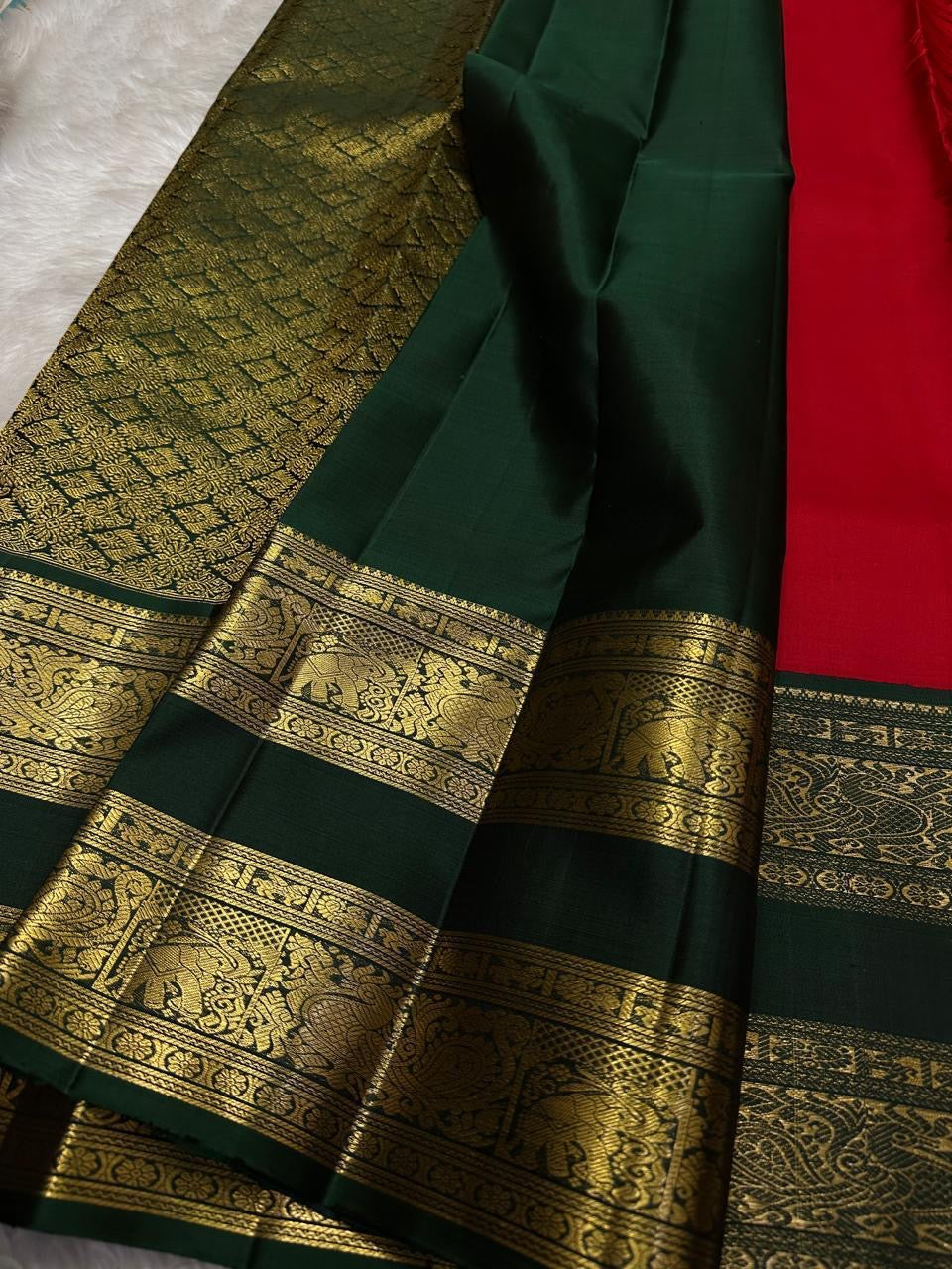 Close-up of deep green zari woven border with elephant and peacock motifs on Kanchipuram silk saree