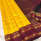 Marigold Yellow & Arakku Pure Silk Kanchipuram Saree
Classic kattam checks across the radiant marigold body
Deep arakku-maroon korvai borders with coin medallion zari
Rich maroon pallu with traditional zari  motifs
Silk Mark Cert • Ships in 2 weeks
