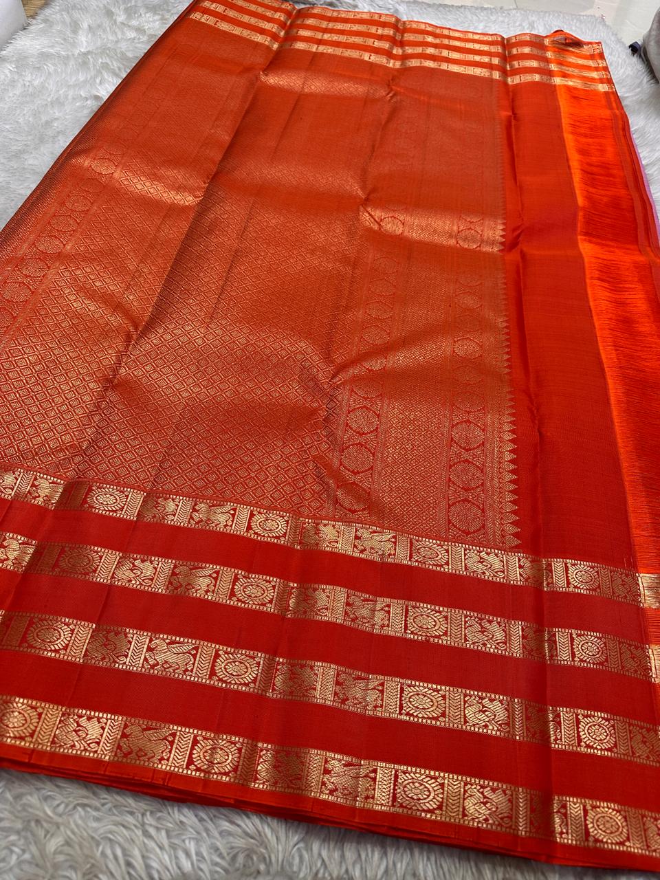 Thamarai Vermillion — Pure Kanchipuram Silk Saree
Soft orchid-pink body with zari lotus buttas and striking vermillion korvai borders, finished with a radiant orange pallu in intricate zari weave.
Silk Mark Certified • Blouse Stitching Available ($30) •