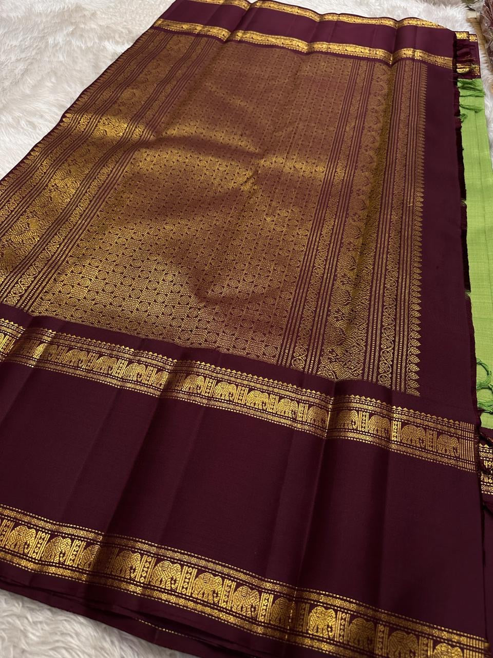 Samprada – Kanchipuram Silk Saree in vibrant cardamom Green & brown
A vibrant parrot green body meets a rich maroon border in this timeless Kanchipuram silk saree