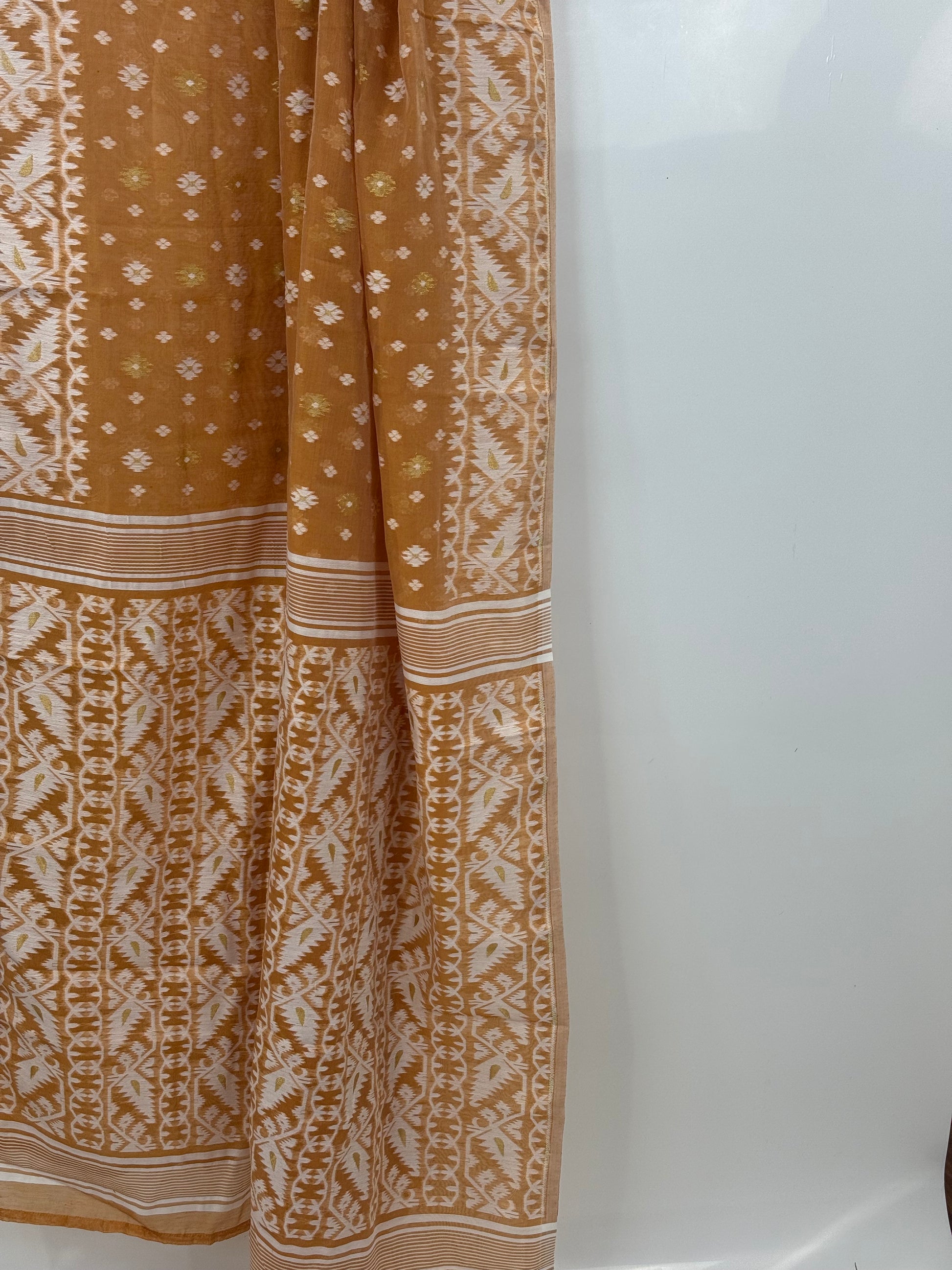 Folded Jamdani saree showing ivory border pattern and subtle gold accents