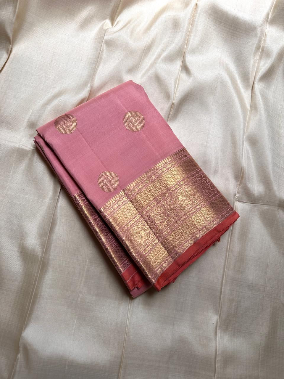 Malini – Pale Pink Pure Silk Kanchipuram Saree with 4G Gold Zari Lotus Buttas and Temple Motif Border
A delicate pale pink drape handwoven in pure silk with shimmering 4G gold zari lotus buttas all over the body.