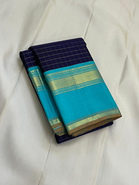 Indigo Teal Kattam – Pure Silk Kanchipuram Saree
Deep Indigo Body with zari Kattam Checks
Teal Contrast Korvai Border with maanga pet and mayil kann border, maanthulir selvedge  , silk mark certified -ships in two weeks