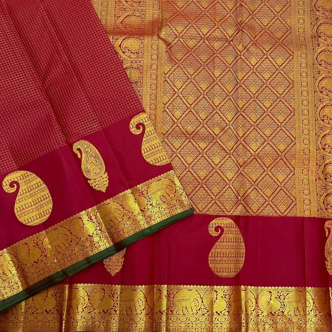 Ushas, Deep Arakku Red Pure Kanchipuram Silk Saree
Radiant Oosi Kattam body with ornate Paisley 2gm Zari
Vanasringaram,Muthuseer,Kamalam border with Fishpettu detailing
Exquisite diamond-pet grid Zari pallu, richly finished with a bold deep green selvedge