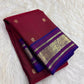 Detail of the woven silk and gold zari border of arakku red pure silk kancheepuram peacock butta saree with indigo violet border