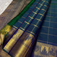A celestial blend of blue and green, this Kanjivaram silk saree ,adorned with Gandaberunda and Kamalam buttas, golden checks, and a majestic thazhampoo Mayil  border. Zari kattam